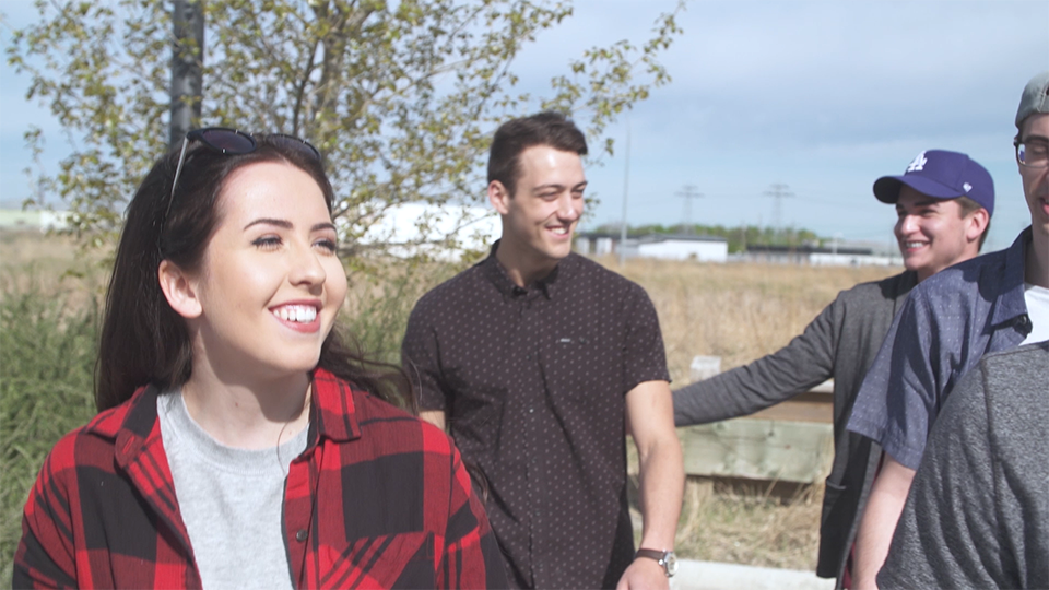 An image of a group of people smiling and walking outside.