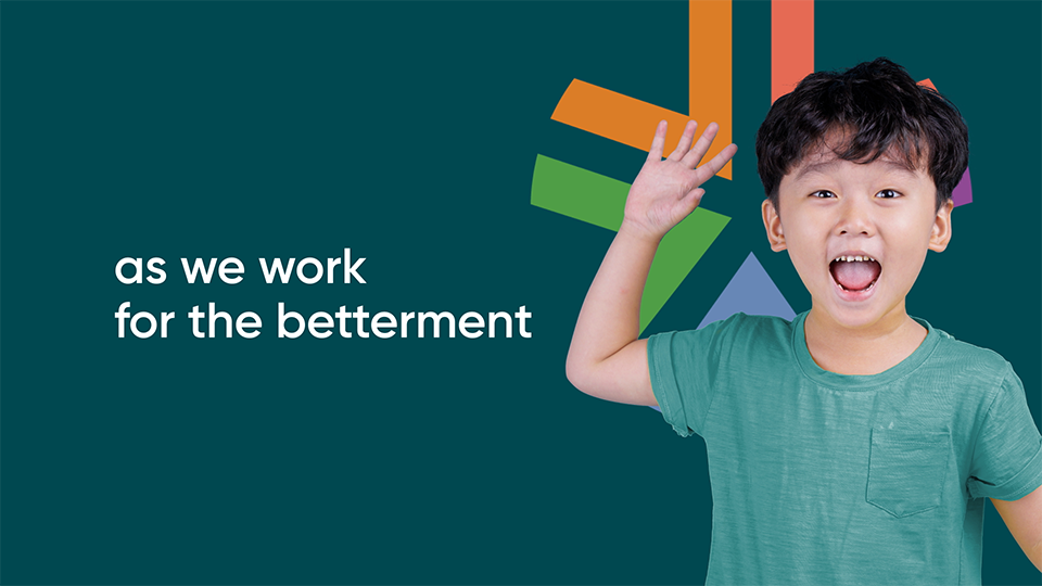A style frame from an animated video, featuring a young boy waving an smiling against a green background, with the ACU logo and the words "As we work for the betterment" to the left of the boy.