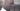 A close up profile image of a black man's face. He is looking downwards and smiling.