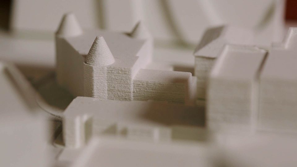 A close up image of a paper model of some buildings from an architectural prototype.
