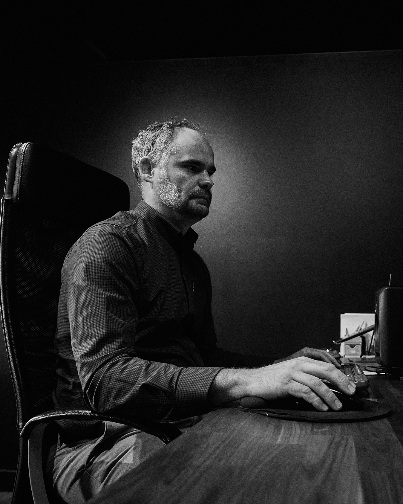 A black and white image of a coelement team member working at a computer.